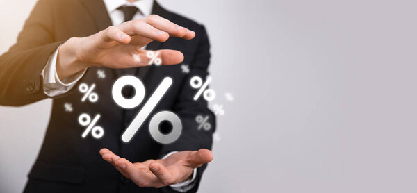 Мужчина держит значок процентной ставки на синем фоне. Процентная ставка Финансовые и ипотечные ставки Concept.Banner с копировальным пространством.