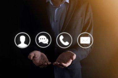 İş adamı el ele tutuşması, ikon telefona, postaya, telefona, telefona, mesaja, iletiye ve kişiye, kullanıcıya basmak. Müşteri hizmetleri çağrı merkezi bizimle konsept bağlantı kurar. Banner, kopyalama alanı. İletişim Yöntemleri
