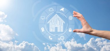 İş adamı ev ikonunu tutuyor. Marketin ev kontrollü, akıllı ev ve ev otomasyon uygulaması konsepti. PCB tasarımı ve akıllı telefonu olan kişi. Yenilik teknolojisi internet ağı kavramı