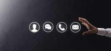 İş adamı el ele tutuşması, ikon telefona, postaya, telefona, telefona, mesaja, iletiye ve kişiye, kullanıcıya basmak. Müşteri hizmetleri çağrı merkezi bizimle konsept bağlantı kurar. Banner, kopyalama alanı. İletişim Yöntemleri