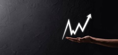 İş adamı satış verilerini ve ekonomik büyüme grafiğini elinde tutuyor. İş planlama ve strateji. Takas ticareti analiz ediliyor. Finansal ve bankacılık. Teknoloji dijital pazarlama. Kâr ve büyüyen plan.