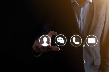 İş adamı el ele tutuşması, ikon telefona, postaya, telefona, telefona, mesaja, iletiye ve kişiye, kullanıcıya basmak. Müşteri hizmetleri çağrı merkezi bizimle konsept bağlantı kurar. Banner, kopyalama alanı. İletişim Yöntemleri