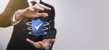 İşadamı poligon kalkanını kene ikonu ile düşük tutuyor.Güvenli Erişim Sistemi Konsepti. Yatırım için İş Mali Garanti. Antivirüs konsepti. Teknoloji güvenliği. Koruma ağı, güvenli veri.