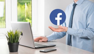 Onok, Ukrayna - 14 Temmuz 2021: İş adamı elinde, tıklama, Facebook simgesi tutuyor. Sosyal ağ. Küresel ağ ve veri müşteri bağlantısı. Uluslararası ağ