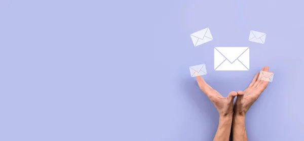 Businessman hand holding letter icon,email icons.Contact us by newsletter email and protect your personal information from spam mail.Customer service call center contact us.Email marketing newsletter