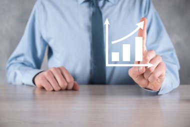 İş adamı artan ekran grafiği, pozitif büyüme ikonu okları üzerinde duruyor. Yaratıcı iş grafiğine yükselen oklarla işaret ediyor. Finansal, ticari büyüme kavramı.