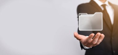 İş adamı dizin simgesini tutuyor. Belge Yönetim Sistemi veya modern bilgisayar bilişim danışmanı tarafından kurulmuş DMS yönetici dosyaları ve kurumsal dosyaları arıyor. İş işleme