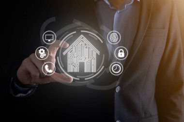 İş adamı ev ikonunu tutuyor. Marketin ev kontrollü, akıllı ev ve ev otomasyon uygulaması konsepti. PCB tasarımı ve akıllı telefonu olan kişi. Yenilik teknolojisi internet ağı kavramı