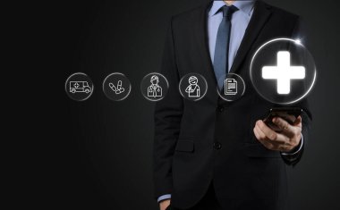 İş adamının elinde sanal ve tıbbi ağ bağlantısı simgeleri var. Covid-19 salgını insanları bilinçlendirir ve sağlık hizmetlerine dikkat çeker. Doktor, belge, ilaç, ambulans, hasta ikonu