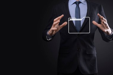 İş adamı dizin simgesini tutuyor. Belge Yönetim Sistemi veya modern bilgisayar bilişim danışmanı tarafından kurulmuş DMS yönetici dosyaları ve kurumsal dosyaları arıyor. İş işleme