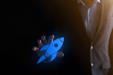 Soyut dijital roket ikonu taşıyan iş adamı konsepti fırlatılıyor ve yükseliyor.