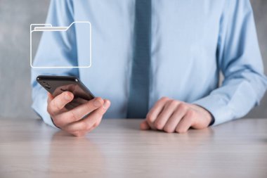 İş adamı dizin simgesini tutuyor. Belge Yönetim Sistemi veya modern bilgisayar bilişim danışmanı tarafından kurulmuş DMS yönetici dosyaları ve kurumsal dosyaları arıyor. İş işleme