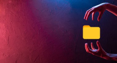 İş adamı dizin simgesini tutuyor. Belge Yönetim Sistemi veya modern bilgisayar bilişim danışmanı tarafından kurulmuş DMS yönetici dosyaları ve kurumsal dosyaları arıyor. İş işleme