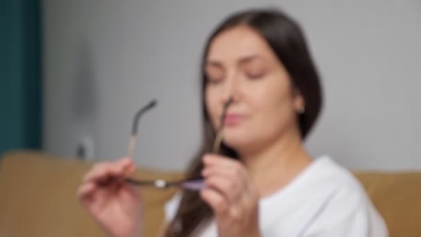 Verschwommene Frau setzt Brille auf und lächelt glücklich, wenn sich der Blick fokussiert — Stockvideo