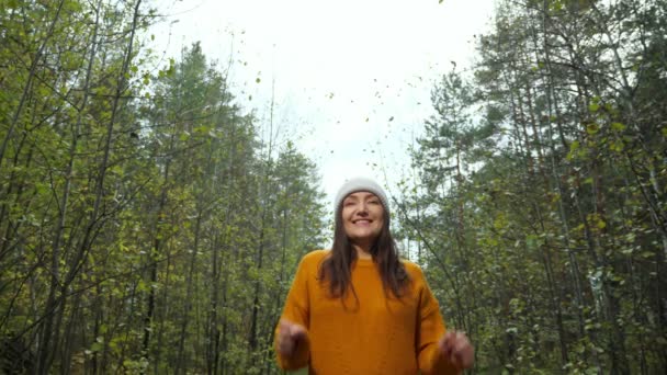 Mulher positiva no chapéu levanta as mãos passando tempo na floresta — Vídeo de Stock
