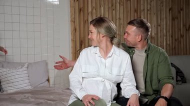 Küçük çocuk koşar ve hamile anne babasının yanında oturur.