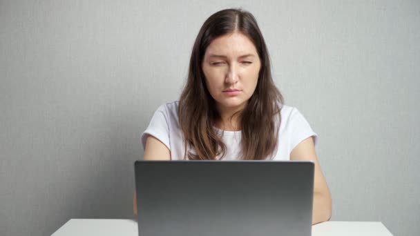 Mulher com visão pobre coloca em óculos olhando para o laptop — Vídeo de Stock