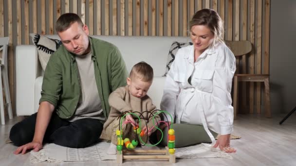 Kleiner Junge spielt mit Puzzle-Spiel in der Nähe der Eltern — Stockvideo