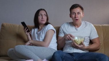 Erkekler, esmer bayanın yanında oturup televizyon izlemekten zevk alır.