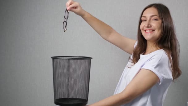 幸せな女性はゴミ箱に視力メガネを捨てる — ストック動画