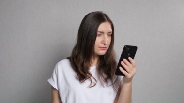 Gözleri iyi görmeyen bir kadın telefon ekranına yakından bakar.