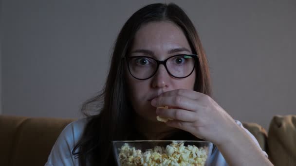 Η κυρία με το τρομαγμένο πρόσωπο τρώει ποπκόρν βλέποντας ταινία τρόμου — Αρχείο Βίντεο