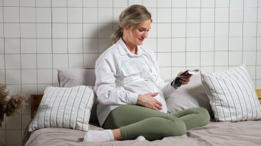 Hamile kadın ultrason fotoğrafına bakarken karnına inme iniyor.