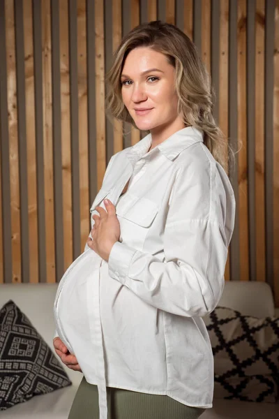 Bella donna incinta abbraccia la pancia e sorride felicemente — Foto Stock