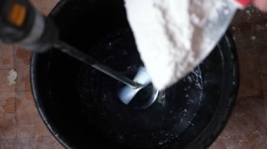 İnşaatçı inşaat mikseri kullanarak havanı kovaya karıştırıyor