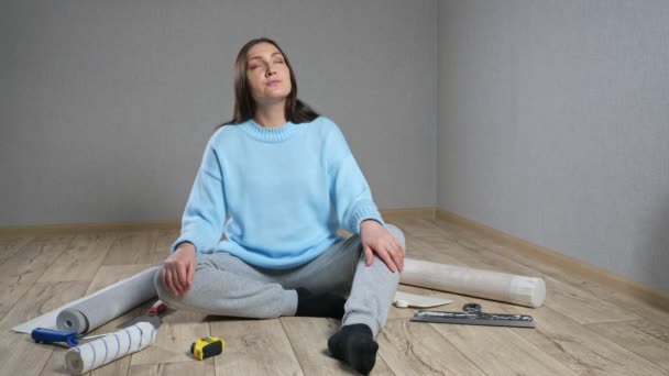 Lady geniet van kamer renovatie zitten op de vloer tussen materialen — Stockvideo