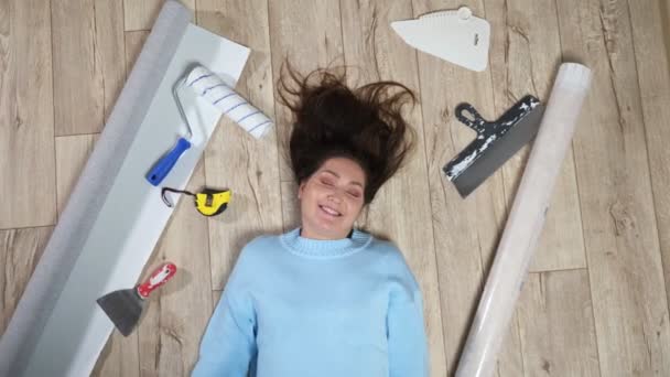 Žena leží na podlaze mezi roztroušenými stavebními materiály — Stock video