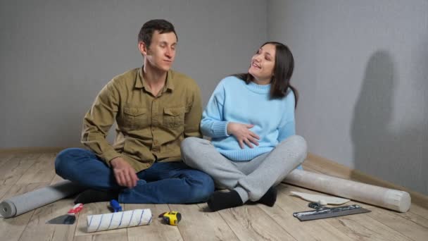 Pasangan ini menikmati renovasi kamar sambil duduk di lantai parket — Stok Video