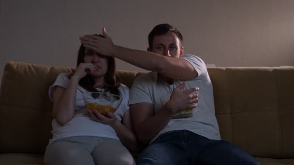 Homem fecha olhos de senhora para não assistir momento terrível no filme — Vídeo de Stock