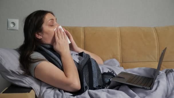 Zieke vrouw met loopneus werkt op afstand met behulp van laptop — Stockvideo