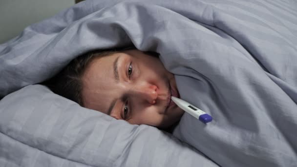 Brunette jeune femme au nez qui coule attrape froid et mesure la température — Video