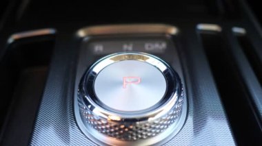 Sürücü vites panelini değiştirerek arabayı park moduna sokuyor