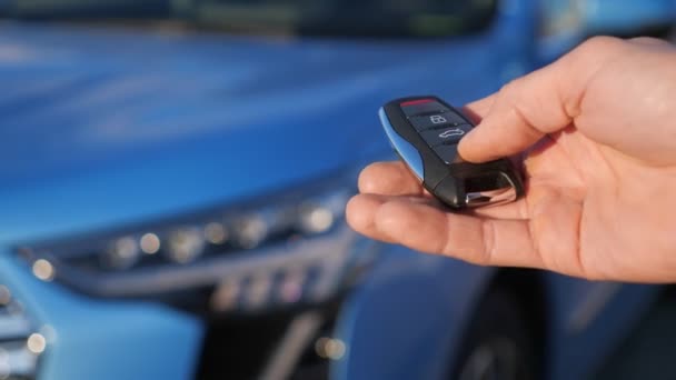 Człowiek usuwa sygnalizację z samochodu za pomocą klucza zdalnego — Wideo stockowe