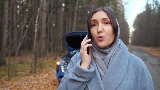 Mujer se para cerca de coche roto pidiendo ayuda en la carretera — Vídeos de Stock