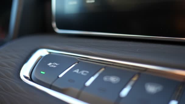 Man presses button and turns off air conditioner to regulate heat in car on black dashboard of automobile — Stock Video