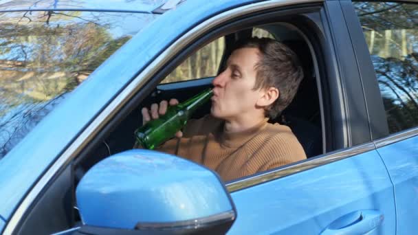 Водитель пьет алкоголь из бутылки в салоне автомобиля после работы — стоковое видео