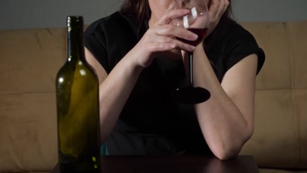 Unerkennbar beschwipste Frau mit gestresstem Gesichtsausdruck trinkt Wein — Stockvideo