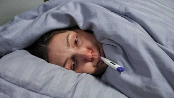 Morena mujer joven con secreción nasal captura frío y mide la temperatura — Foto de Stock