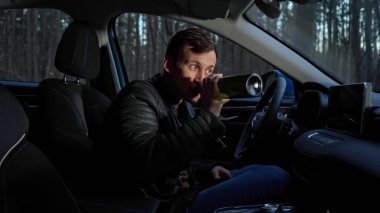 Şoför polis için gizlice şişeden alkol içer.