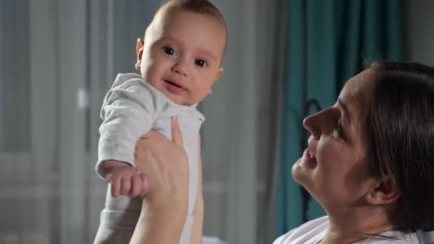 어린 갈색 머리의 어머니는 침실에 앉아 있는 사내 아기를 만난다 — 비디오