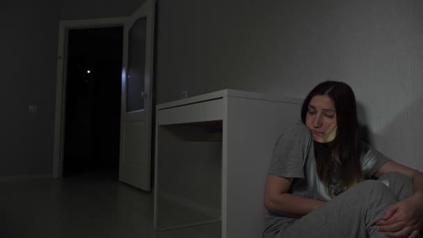 Молода жінка ховається за столом від грабіжника — стокове відео