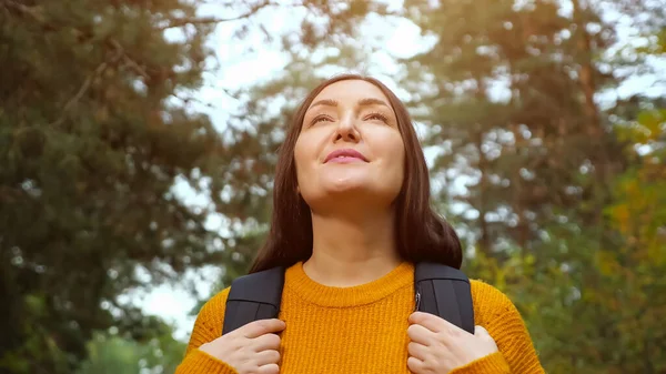 Счастливая женщина наслаждается свежим воздухом среди дикого леса — стоковое фото
