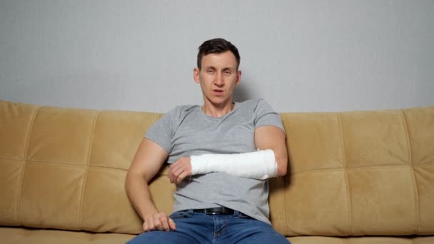 Brunet Mann pflückt Nase mit gebrochenem Arm — Stockvideo