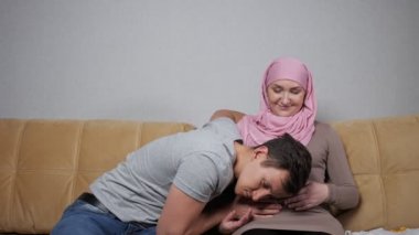 Müslüman anne ve baba gülümseyen hamile karnını okşarlar