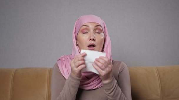 Musulmana en hijab captura frío y estornuda en servilleta — Vídeos de Stock