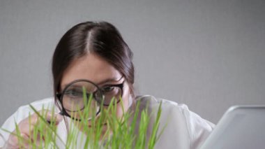 Uzman laboratuardaki yeşil çimlere bakıyor.